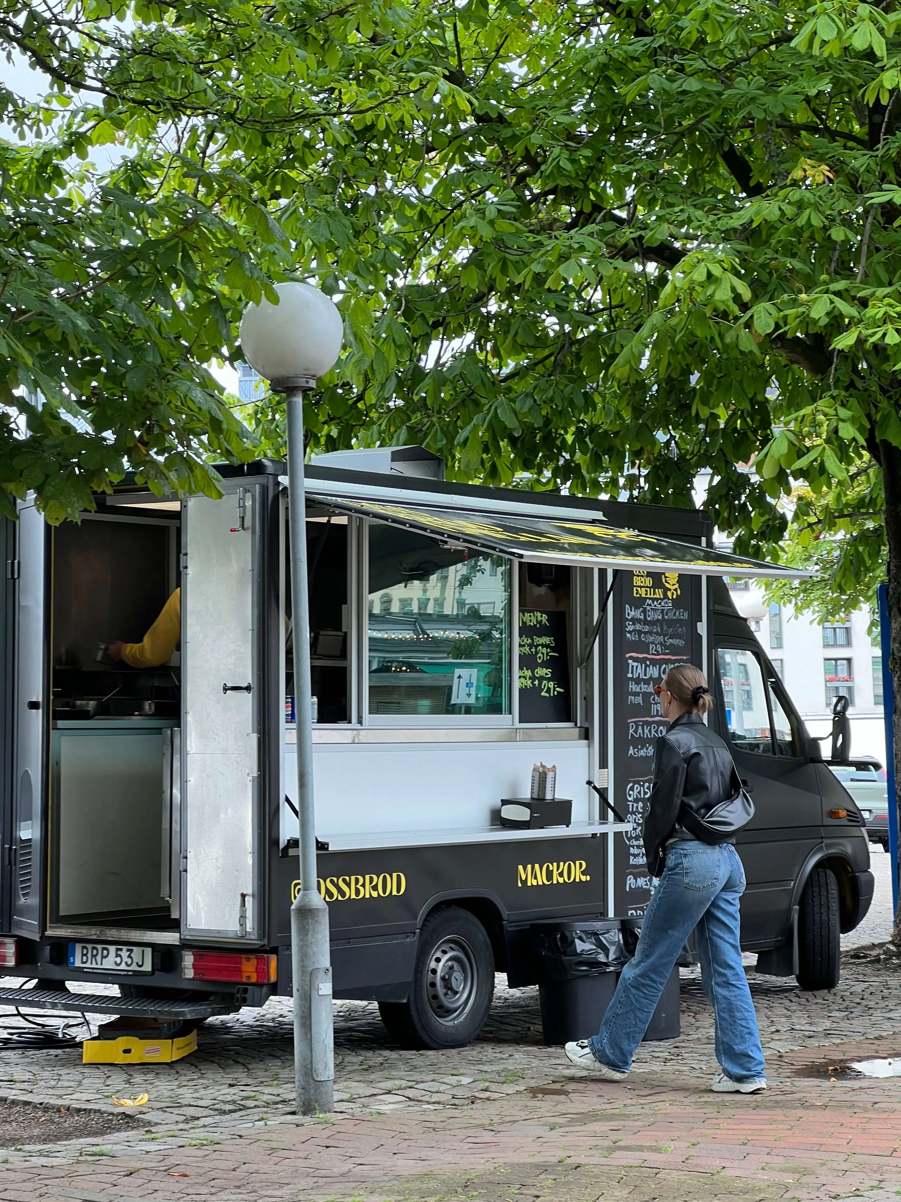 Foodtrucken med öppen lucka och handskriven meny på en gata i Göteborg