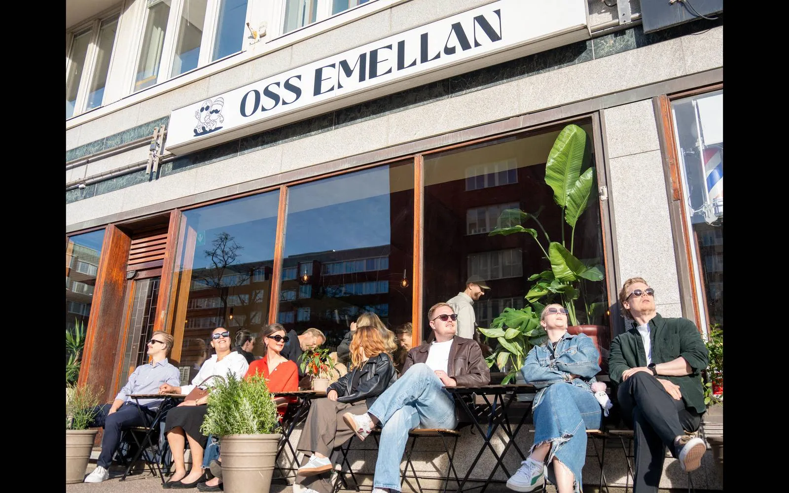 Gäster i solen på uteserveringen utanför Oss Emellan på Karl Johansgatan