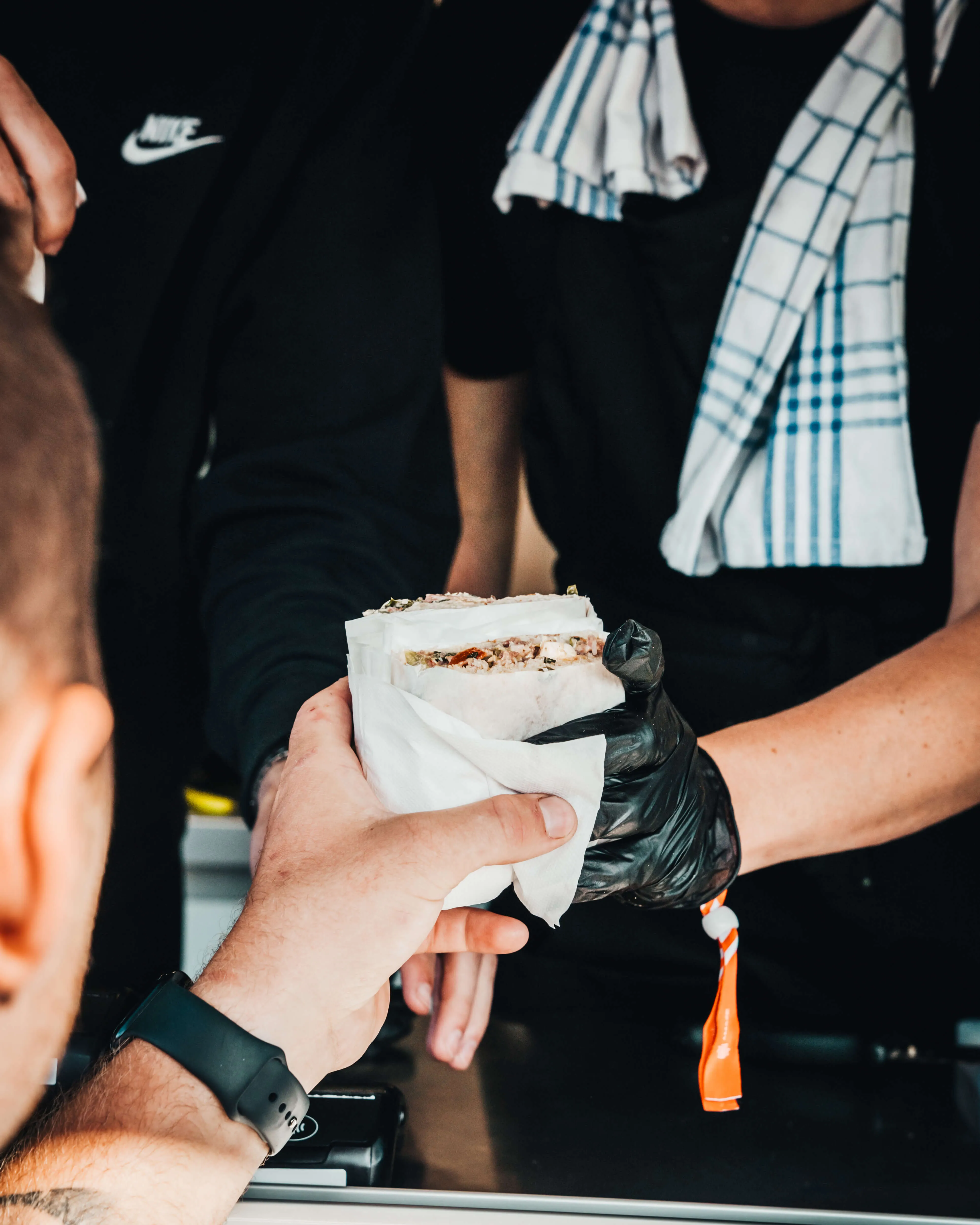 En macka räcks över serveringsdisken till en gäst